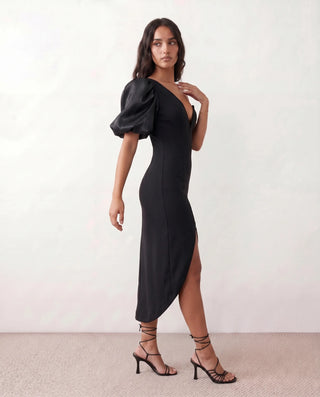 Avery Cocktail Asymmetric Neck Midi Dress in black — side view